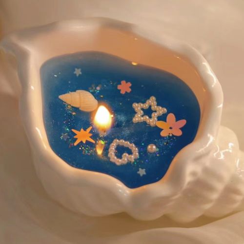Conch-shaped smokeless scented candle with floral Chypre notes featuring shimmering seabed design