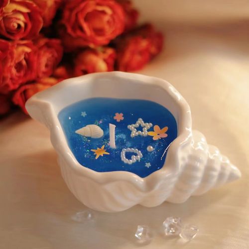 Conch-shaped smokeless scented candle with floral Chypre notes featuring shimmering seabed design