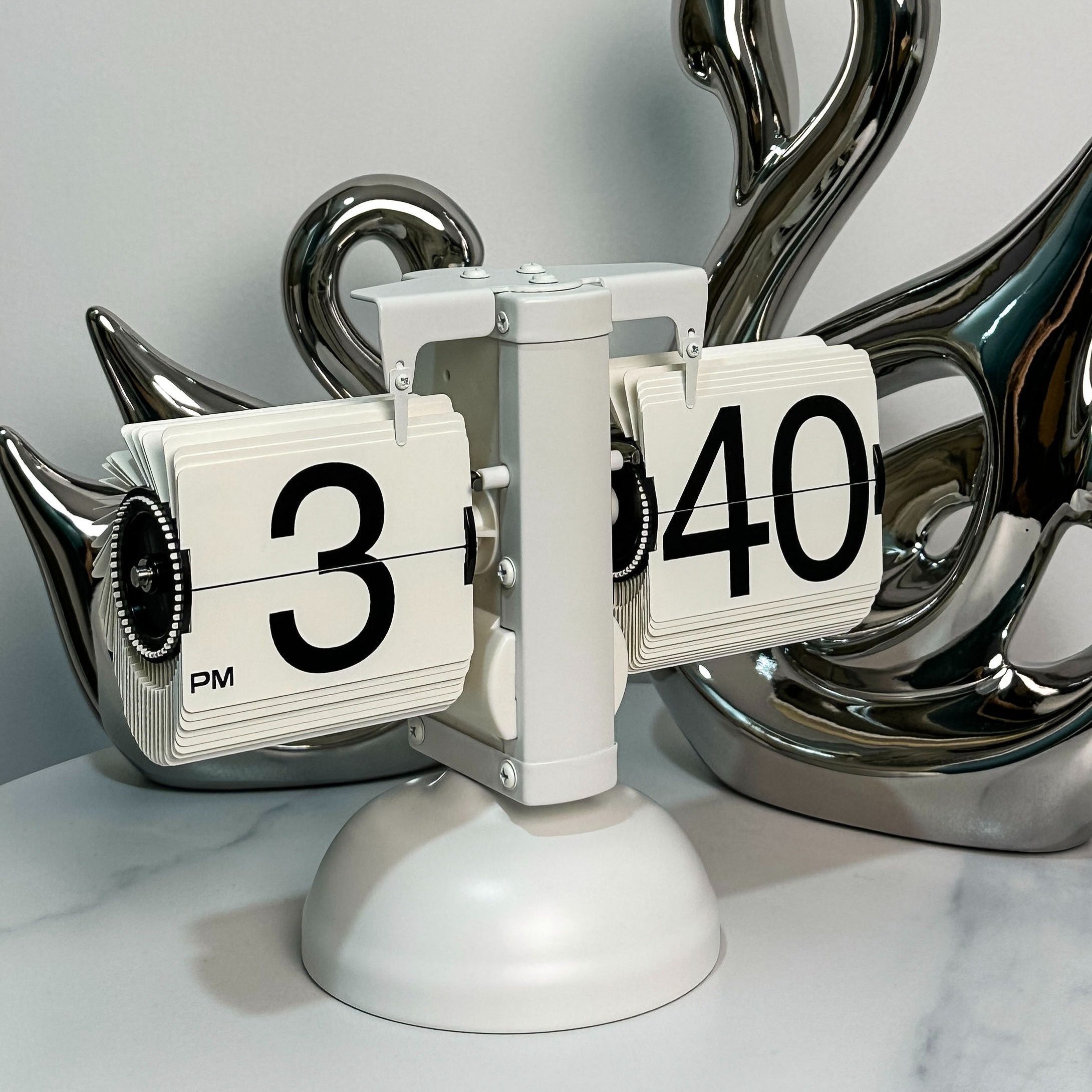 Creative automatic page - turning clock. A retro living room ornament with a modern and simple design. It's the Miaoke table clock, a single - leg small balance flip - card clock