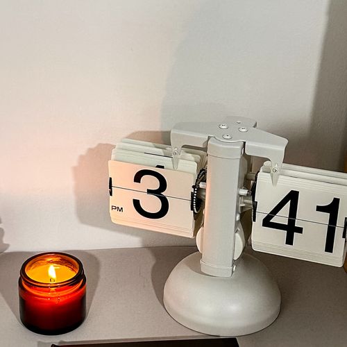 Creative automatic page - turning clock. A retro living room ornament with a modern and simple design. It's the Miaoke table clock, a single - leg small balance flip - card clock