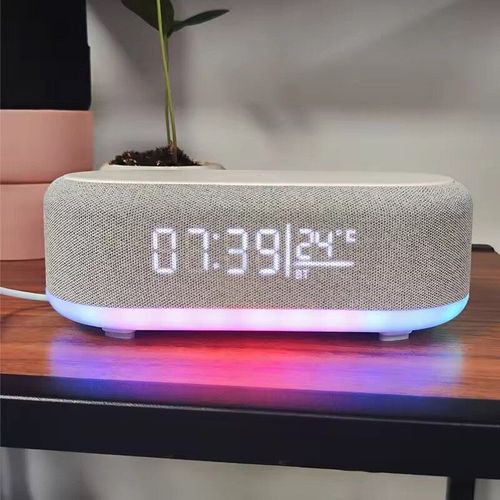 Este alto-falante de clock de quatro lados integra carregamento rápido sem fio de 15W, display de temperatura de clock, luzes de ambiente RGB e alto-falante Bluetooth.  Isso mantém a área de trabalho organizada sem ocupar espaço.  A aparência do tecido é simples e versátil.  Ele carrega eficientemente, mostra claramente o tempo e a temperatura, e as luzes podem mudar conforme a cena.  É um item prático e esteticamente agradável para quartos e mesas de escritório.