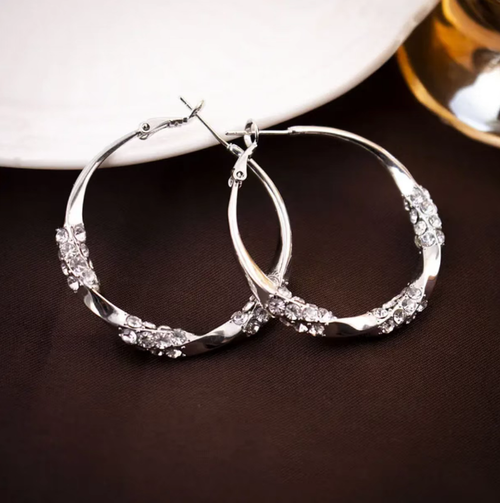 Estes brincos em forma de anel com zircônia e diamante torcido apresentam um design redondo clássico, com zircões delicadamente dispostos em um padrão. A superfície é lisa e brilhante. O fecho de encaixe garante uma fixação segura. A superfície metálica é polida e lisa. É versátil e adequado para diversos tipos de looks, ideal tanto para uso profissional como casual. Com a manutenção adequada, pode conservar sua textura por muito tempo.