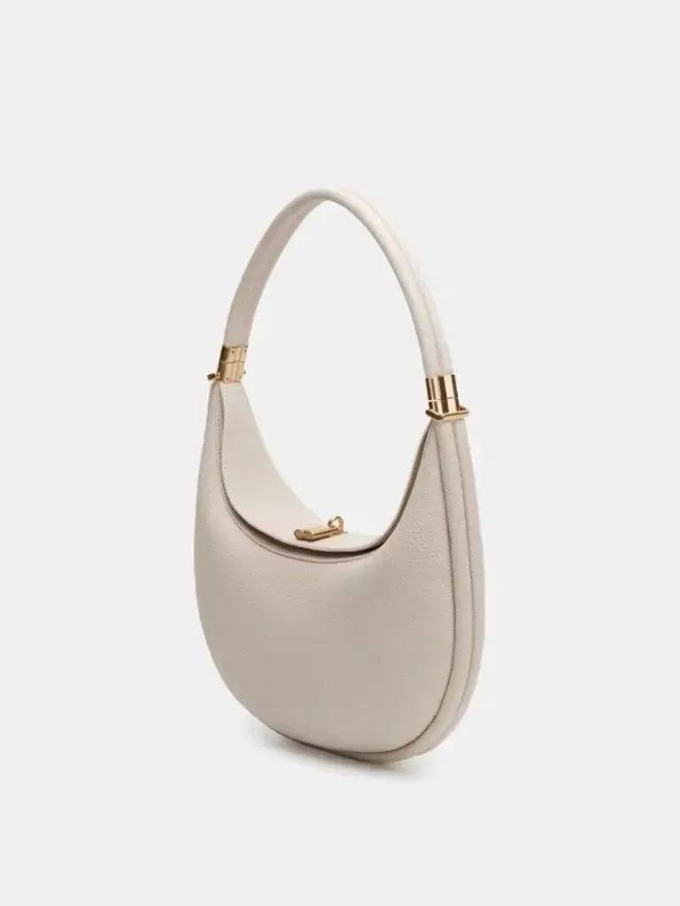Sophisticated understated-luxury crescent-shaped handbag a versatile solid-color bag perfect for work commuting or everyday use can be carried by hand worn over the shoulder crossbody or tucked under the arm.