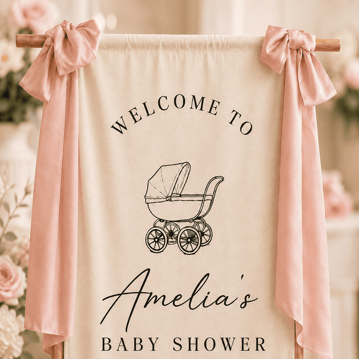 Close-up personalized baby shower welcome banner styled with pink ribbons