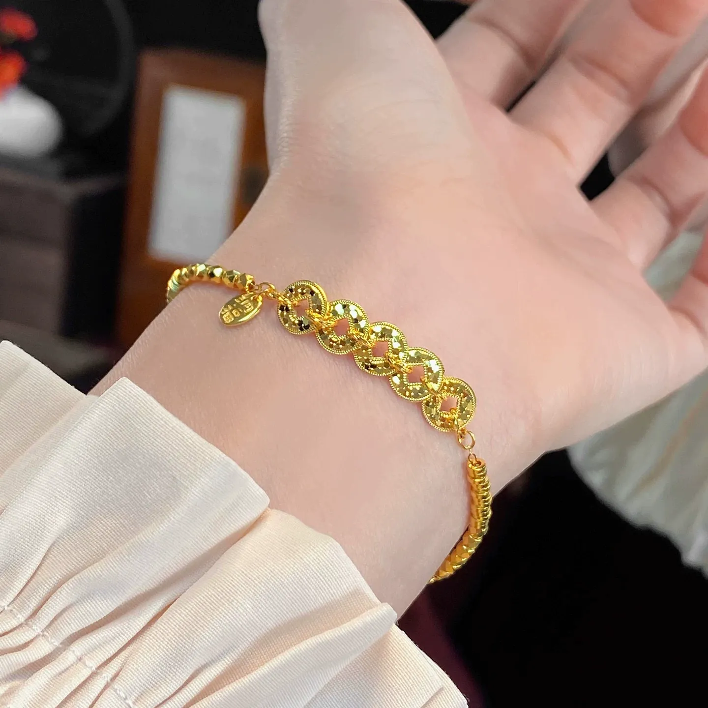 This is a delicate bracelet featuring a five-emperor coin design with a high-quality gold plating and color retention.