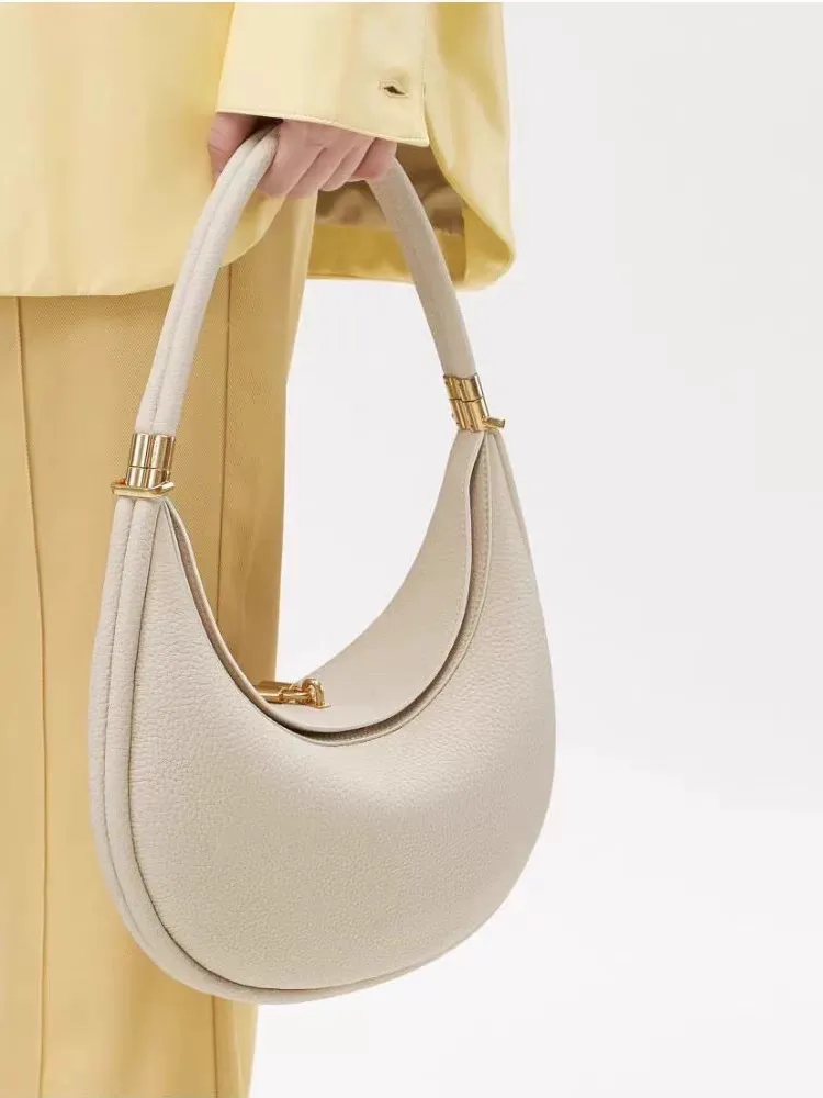 Sophisticated understated-luxury crescent-shaped handbag a versatile solid-color bag perfect for work commuting or everyday use can be carried by hand worn over the shoulder crossbody or tucked under the arm.
