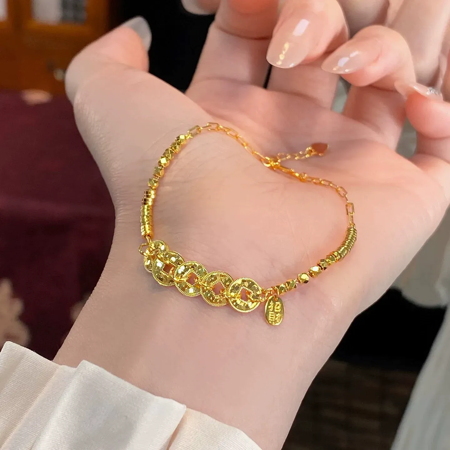 This is a delicate bracelet featuring a five-emperor coin design with a high-quality gold plating and color retention.