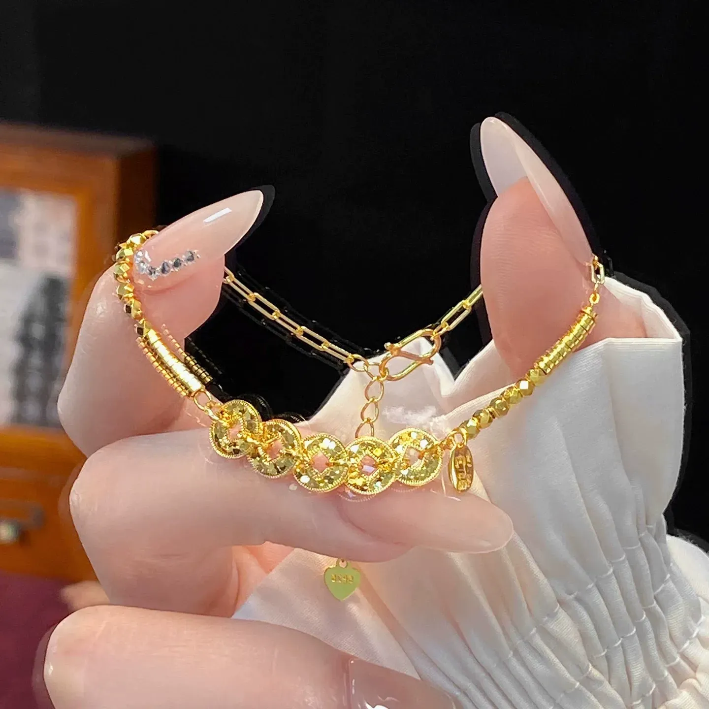 This is a delicate bracelet featuring a five-emperor coin design with a high-quality gold plating and color retention.