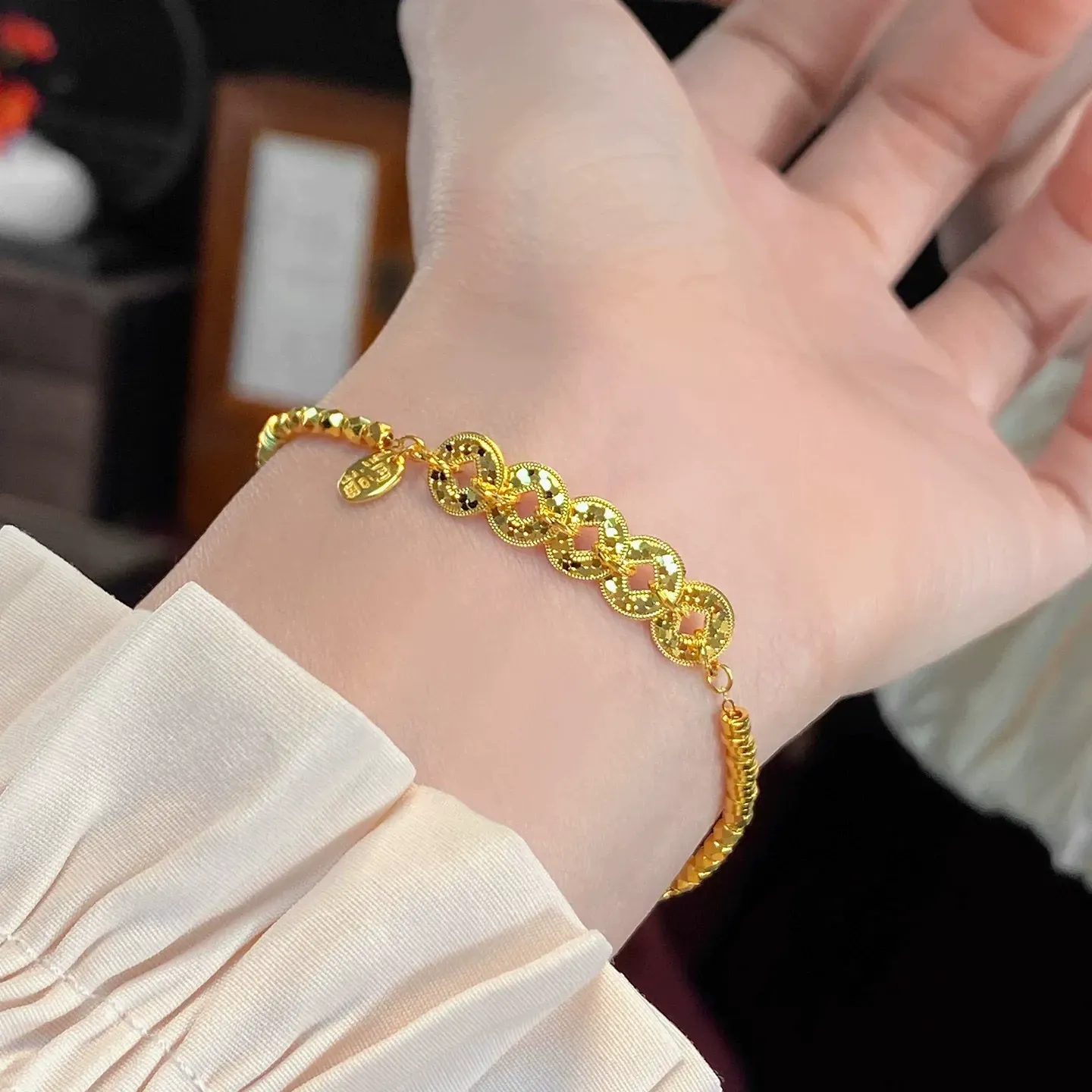 This is a delicate bracelet featuring a five-emperor coin design with a high-quality gold plating and color retention.