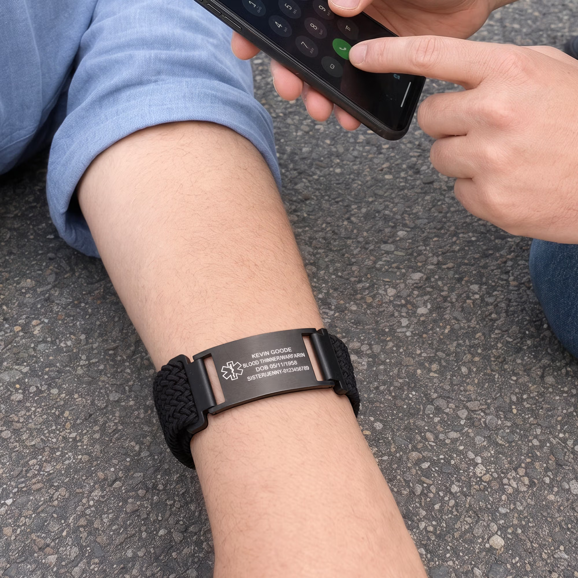 Schwarzes Notfallarmband am Handgelenk beim Benutzen eines Smartphones