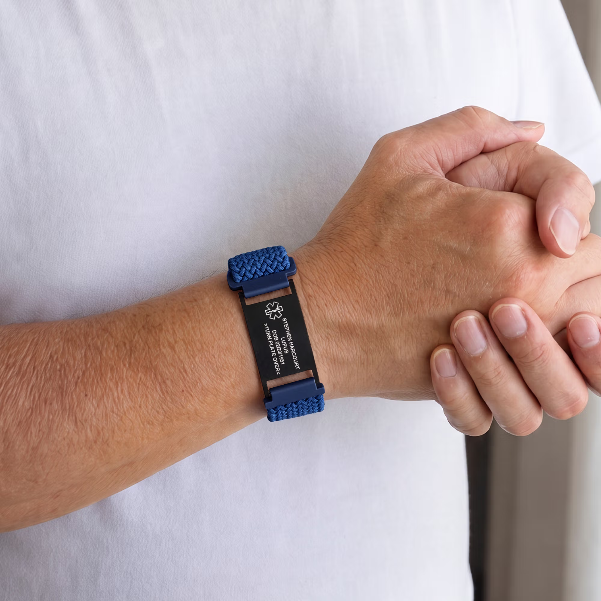 Blaues Notfallarmband am Handgelenk, kombiniert mit einem weißen Hemd