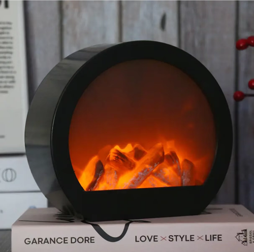 This LED imitation charcoal flame lamp features a semi-circular shape with a transparent window and is equipped with simulated charcoal inside. The LED light simulates the glow of charcoal fire, without any open flame or smoke. It is only used for creating an atmosphere and does not have a heating function. When placed on the table, it is suitable for creating a cozy atmosphere in homes or guesthouses. When using it, keep it away from flammable items.