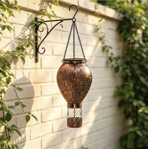 A hot air balloon-shaped solar ironwork pendant light. With a retro distressed material that is rust-proof and waterproof. The design features a hollow mushroom and butterfly pattern. It casts beautiful light at night. Solar-powered for self-charging. Controlled by light, it automatically turns on and off without the need for wiring. Suitable for hanging in the garden or balcony, it can easily create a cozy and pleasant outdoor atmosphere.