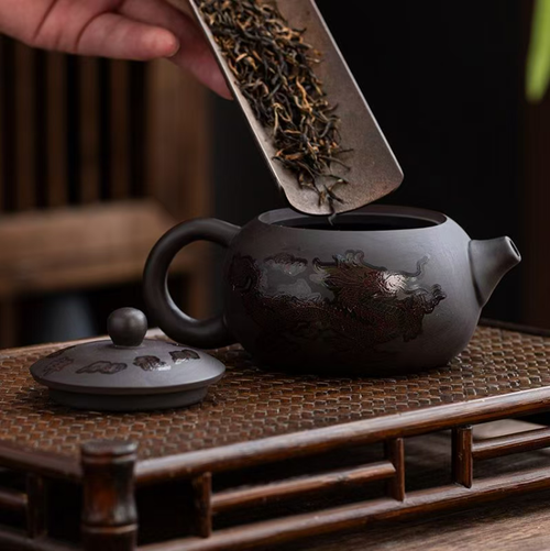 The dragon and phoenix teapot that changes color when it comes into contact with water is a traditional Chinese tea set with unique craftsmanship. It is usually made of purple clay and the body of the teapot is decorated with dragon and phoenix patterns. The color will change when it comes into contact with water. It is extremely exquisite and very suitable for collection.
