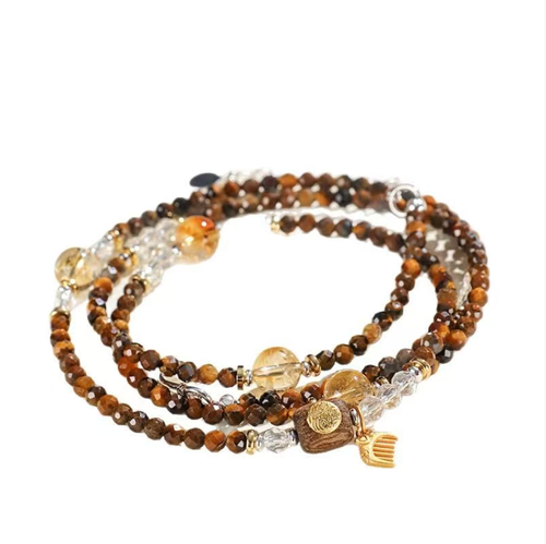 This common jewelry made of agarwood and tiger's eye stone can be used as a necklace or a wrist bracelet. The tiger's eye stone has a golden glow, while the yellow crystal is transparent. It is adorned with a Guanyin pendant and a silver-gilded small comb to bring good luck. It is suitable for various outfits, is gentle on the skin and does not cause discomfort, and is both elegant and convenient for daily use.