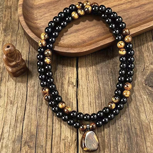 Black obsidian paired with yellow tiger eye stone long cardigan chain. The original stone pendant has a naturally unique texture. The beads are smoothly and roundly polished, and the rope lines are firm and durable. The overall length is moderate, which enhances the figure. It is retro and stable, suitable for various clothing styles, and is suitable for both men and women. It is very suitable for daily wear and as a gift.