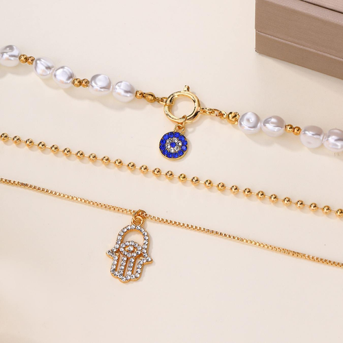 Multi-layered necklace with a gold-plated alloy pearl pendant.