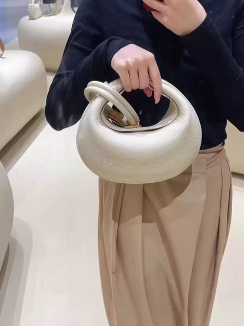 Sophisticated understated-luxury crescent-shaped handbag a versatile solid-color bag perfect for work commuting or everyday use can be carried by hand worn over the shoulder crossbody or tucked under the arm.