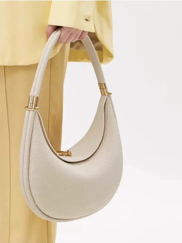 Sophisticated understated-luxury crescent-shaped handbag a versatile solid-color bag perfect for work commuting or everyday use can be carried by hand worn over the shoulder crossbody or tucked under the arm.