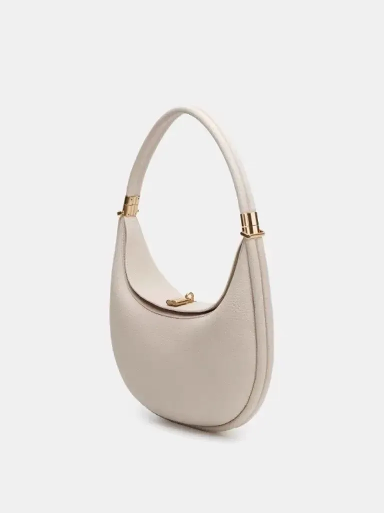 Sophisticated understated-luxury crescent-shaped handbag a versatile solid-color bag perfect for work commuting or everyday use can be carried by hand worn over the shoulder crossbody or tucked under the arm.