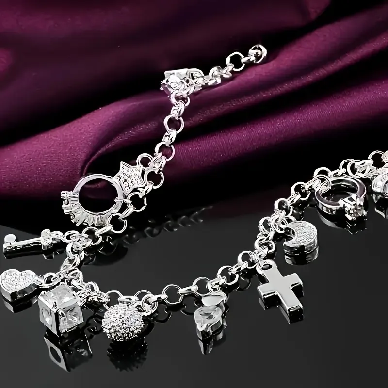 An elegant 925 sterling silver bracelet featuring a heart-shaped key pendant and adorned with 13 exquisite mini-charms, exuding a charming Bohemian style. Boasting a radiant silver luster and meticulous craftsmanship, this fashionable accessory makes an ideal gift for a wife or girlfriend—perfect for birthdays or any special occasion—and serves as a striking, personalized statement piece. (Box not included.)