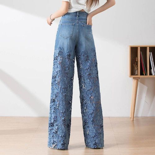 Women's high-waisted blue jeans with wide legs, distressed detailing and lace inserts.