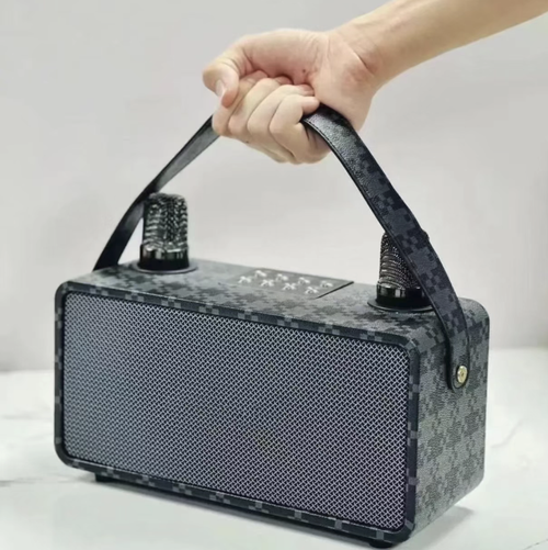 A Bluetooth speaker for karaoke, equipped with two wireless microphones, has a fabric casing and a portable carrying strap. It supports Bluetooth, USB, and memory card playback, offers stereo output, and comes with various singing effects. The built-in battery can be used without power supply, making it suitable for family gatherings and short outdoor activities. It is not suitable for large venues, and high volume can cause distortion.