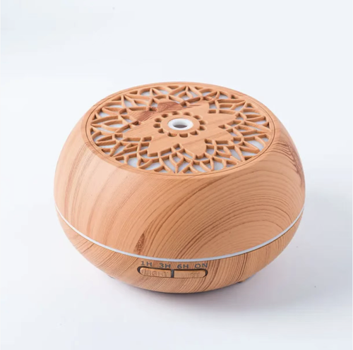 Wood grain perforated aroma diffuser. The imitation wood grain shell is combined with a carved top cover. It supports 1-hour, 3-hour, and 6-hour timing functions as well as a continuous-on mode. The ultrasonic atomization generates fine mist vapor, providing both humidification and fragrance diffusion, along with an ambient night light. It has low operating noise and is suitable for bedrooms, study rooms, and office areas.