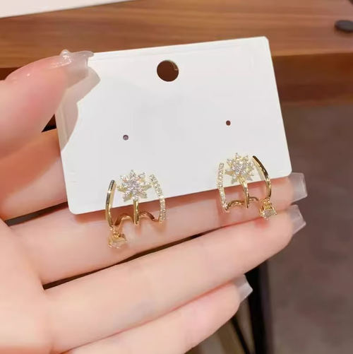 This octagonal star-shaped stud earrings feature an integrated curved design that fits the ear perfectly. The earrings are adorned with small zirconia stones and a delicate pendant, presenting a soft and lustrous appearance. The design is unique and trendy, with a Japanese-Korean style. They are suitable for both daily wear and social gatherings. Proper care during daily use can prevent bumps and exposure to chemicals, ensuring the long-term preservation of the jewelry's quality.