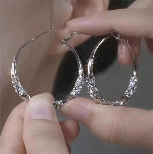 This twisted diamond-set zirconia hoop earrings feature a classic round design, with zircons delicately arranged in a pattern. The surface is smooth and shiny. The snap fastening ensures a secure fit. The metal surface is polished and smooth. It is versatile and suitable for various outfits, suitable for both work and casual wear. With proper maintenance, it can maintain its texture for a long time.