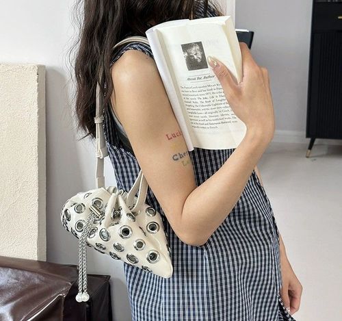 Stylish single-shoulder crossbody bag with openwork drawstring bucket bag, handle with underarm rivets, versatile small bag for women.